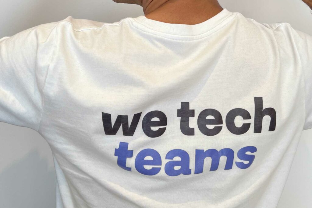 Una persona de espaldas con el lema We teach teams de CrossPoint Academy, en su camiseta