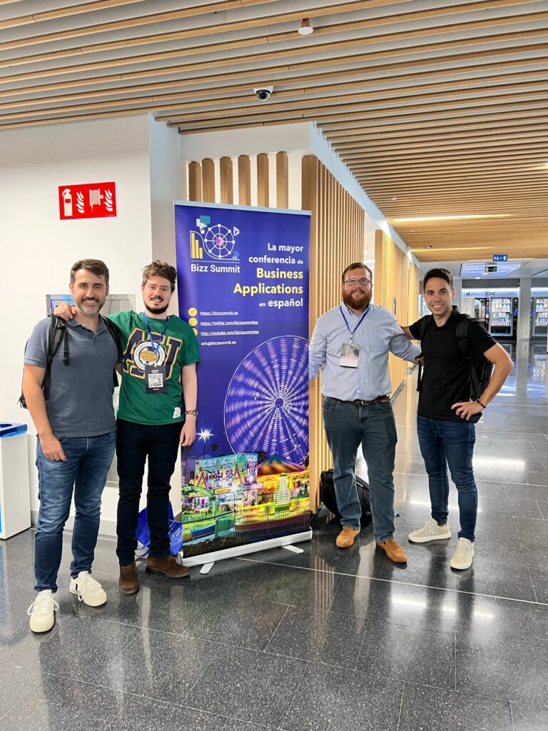 El equipo CrossPoint ante un cartel del evento Bizz Summit Madrid, en septiembre de 2022