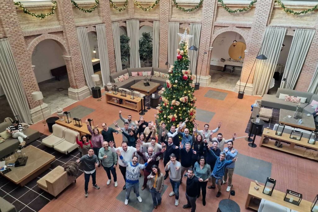 Equipo CrossPoint saludando a la c&aacute;mara desde abajo, junto al &aacute;rbol de Navidad del Parador de Lleida