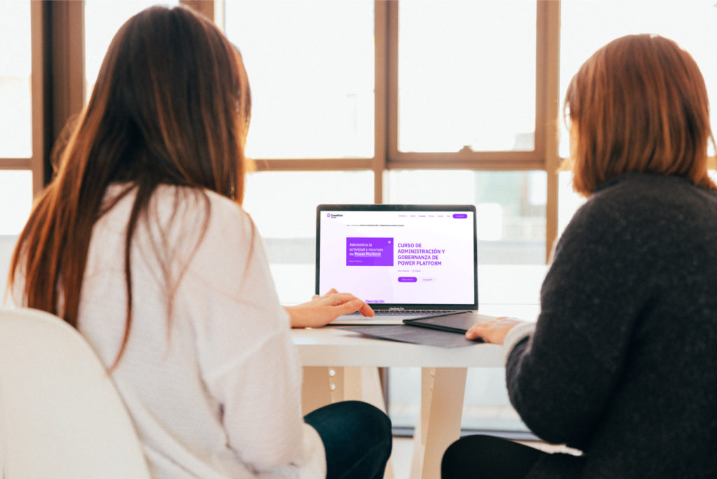 Dos chicas revisan en el ordenador el Curso de Gobernanza de Power Platform de CrossPoint