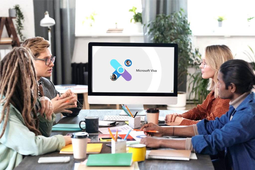 Un grupo de personas trabajando ante una pantalla de ordenador con el logo de Microsoft Viva